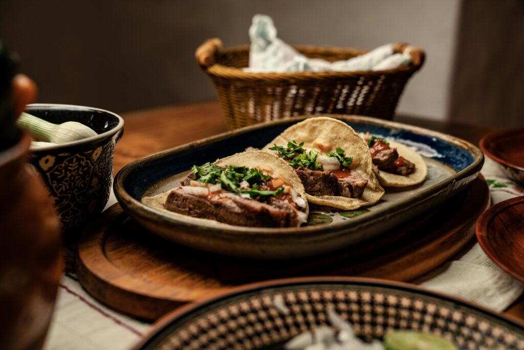 Delicious beef tacos served on a rustic plate with fresh cilantro and onions.